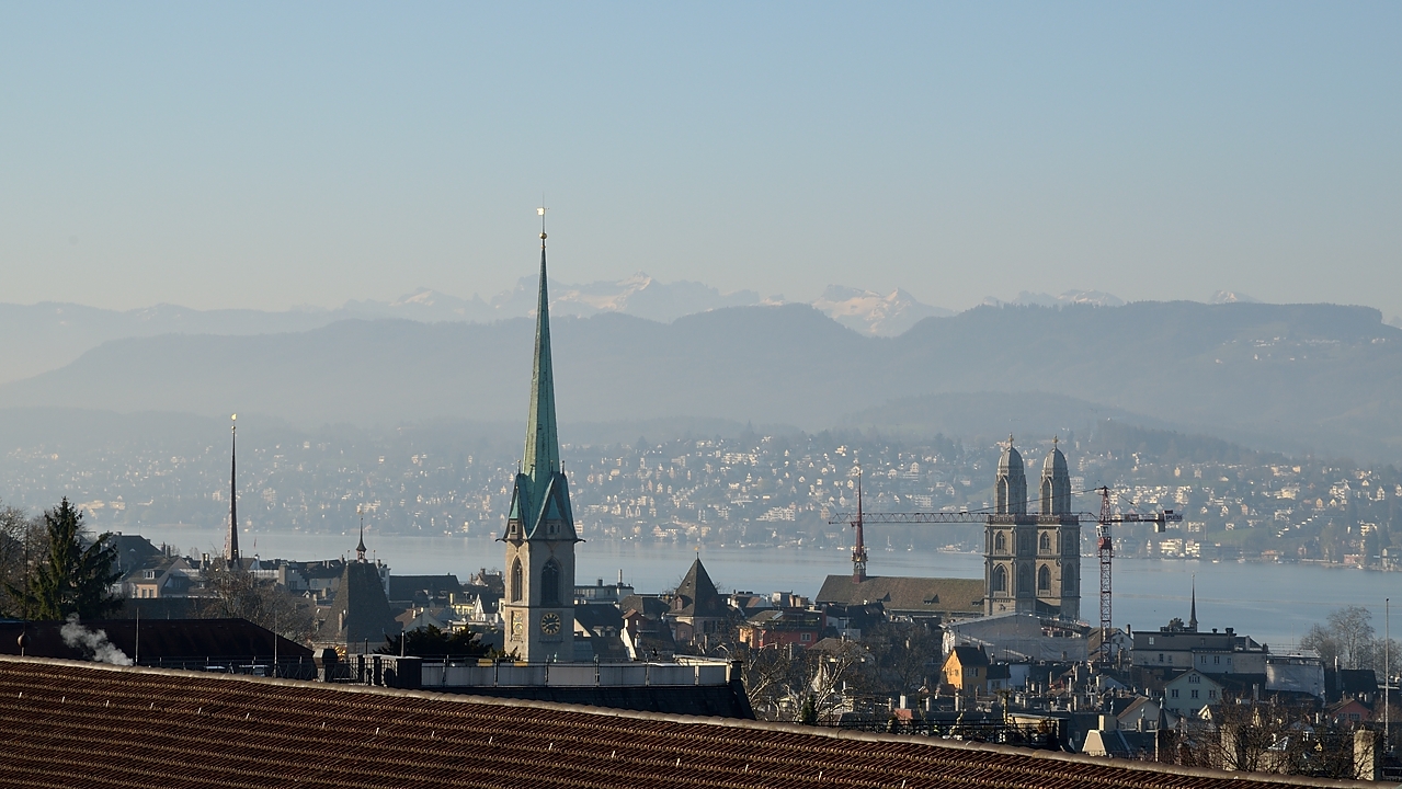 20140320-044-ETHZ.jpg - Views around ETH and university: view from the offices at ETH on the lake and the snow covered mountains not so far away ...and the churches of the city (Frauenmunster and Grossmunster)